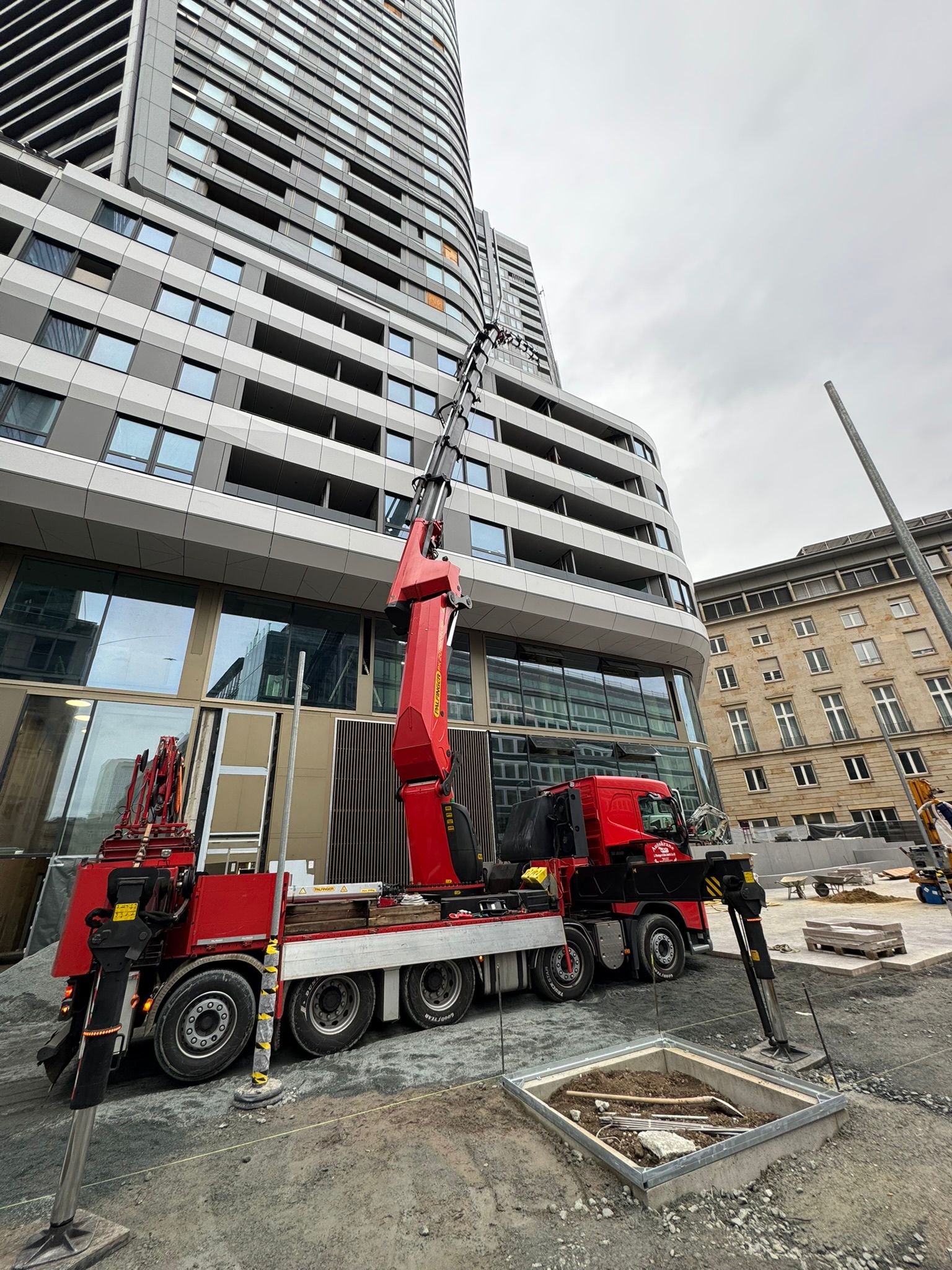 Mobilkran von Pfenninger hebt schwere Lasten auf Baustelle in der Stadt.